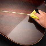 Musicien utilisant huile de soin sur une guitare acoustique en bois.