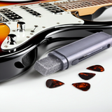 Stylo nettoyeur antirouille pour cordes de guitare poser sur une table a cote de la guitare electrique